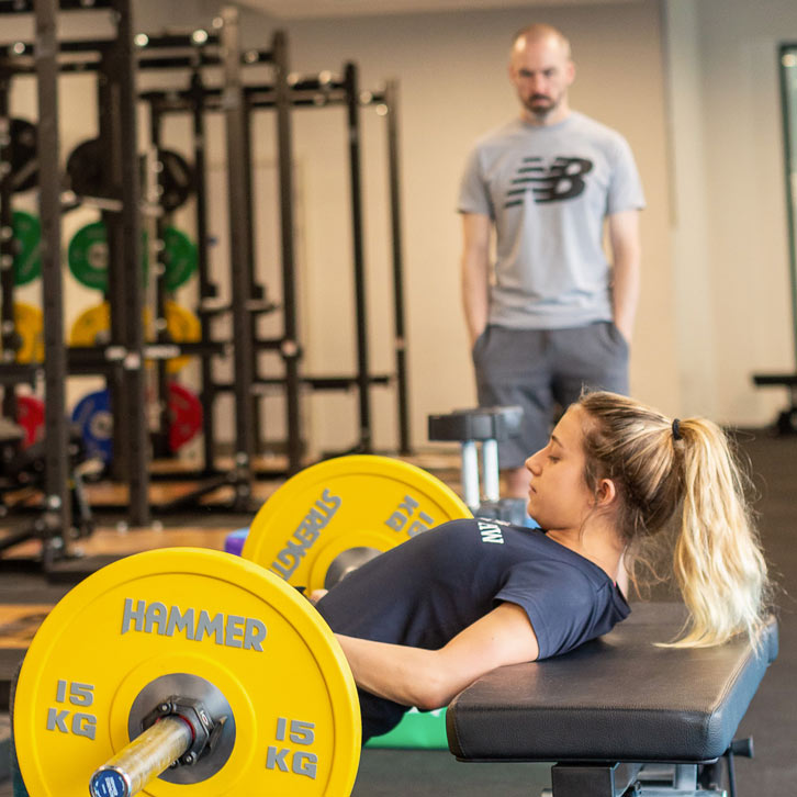 woman performing a barbell hip thrust